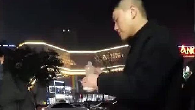 男子对路边摊的烤肠给予了肯定，尝了一口标记了地点再给兄弟一个