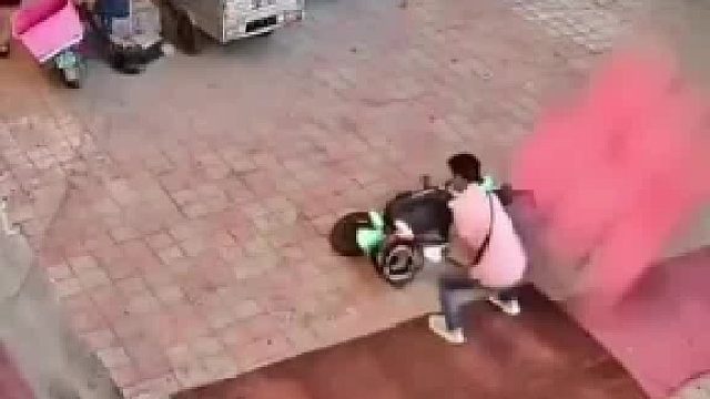 店家提醒有高空坠物，男子赶忙躲进店里后又折返推电动车，险被高空坠物砸中