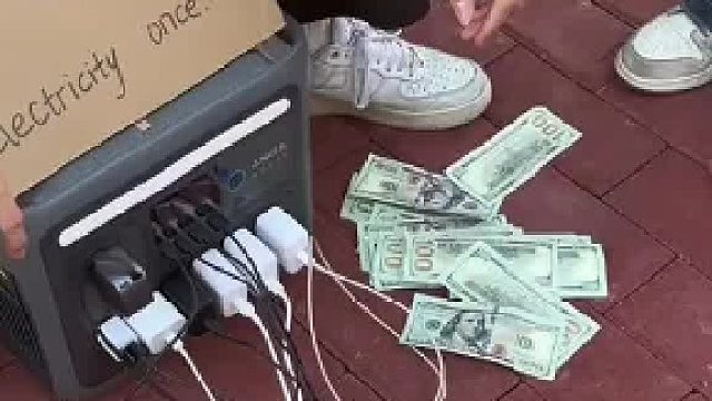 小哥在国外摆摊创业，给路人的手机充电收费