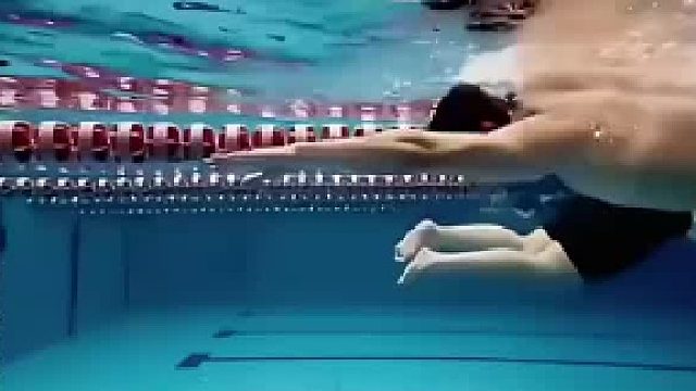 在游泳池转身游，后面正好来个女子练游泳，结果男子直接从圈心钻过去了