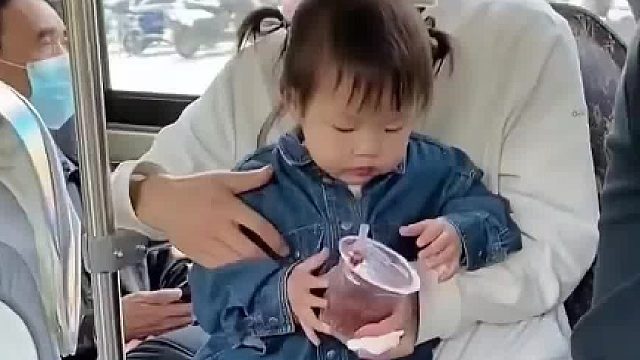 爸爸带娃坐公交，宝宝努力想吃到爸爸手里的吃的，眼睛都不带看一眼的