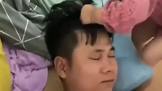 爸爸在床上睡觉，小女孩贴心给爸爸垫枕头，知道疼爸爸但不知道爸爸疼