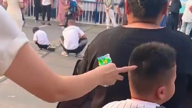 男孩坐在妈妈后座，被人戳了脑瓜，下秒就是无言的默契