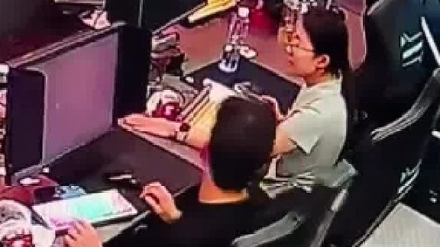 女子失手将旁边男子的电脑关掉，男子无比愤怒又无能为力，叫来老板踢凳子发泄怒火
