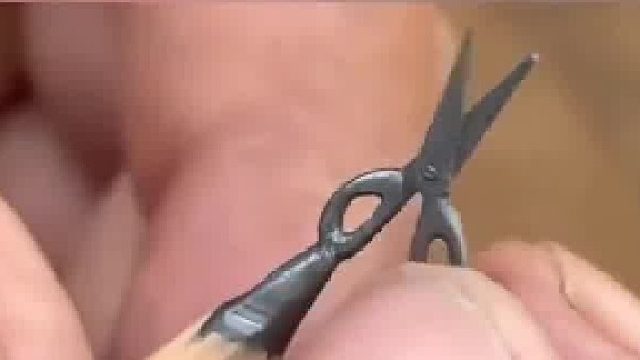 手艺人把铅笔芯雕刻成剪刀模样