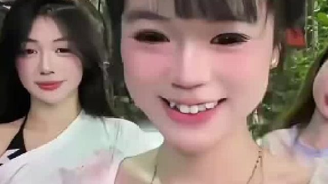 三名女生在街边拍照，一名女子使劲向后拽着同伴的头发