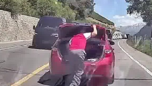 路上堵车，男子下车去后备箱拿吃的，不料下一秒车启动走了  ​