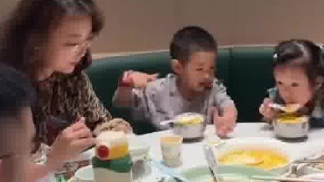 男孩刚给女同学夹完菜，女同学立马给男孩妈妈夹碗里