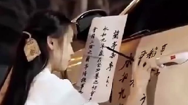 小姐姐街头练毛笔字，路人跃跃欲试，当场演绎书法魅力