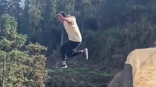 男子夏日在户外展示轻功三连跳，从马路上跳到田坎里，高度看得人心慌​