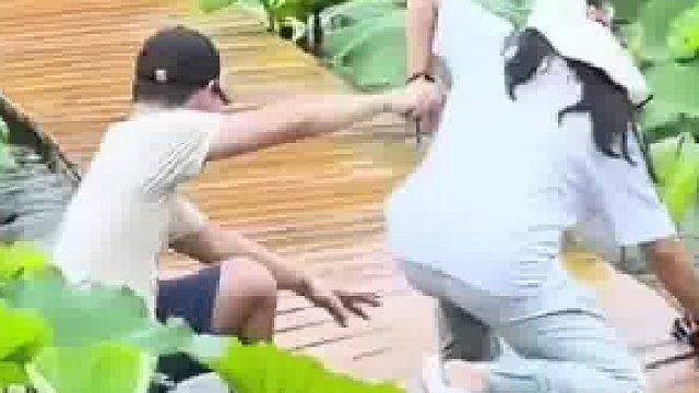 众人手牵手过水桥，结果男生意外掉下去导致同伴也被拽下水​