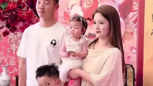 家人为最小的女儿举办了周岁礼，一家人在一起拍照片很快乐