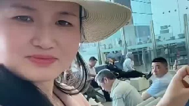 女子在浙江高铁站表演纸牌魔术，后面的乘客的眼光聚焦在女子手中