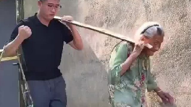 103岁奶奶不服老，拉着孙子一起挑水浇地，孙子将水桶挎在胳膊上