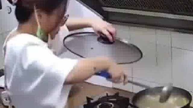 女子在煮饭时油烟机里掉下来一只老鼠，女子连忙盖上了锅盖