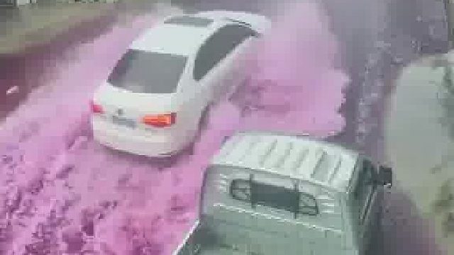 摩托车在积水里压破东西，导致整条街的雨水都被染成粉红色