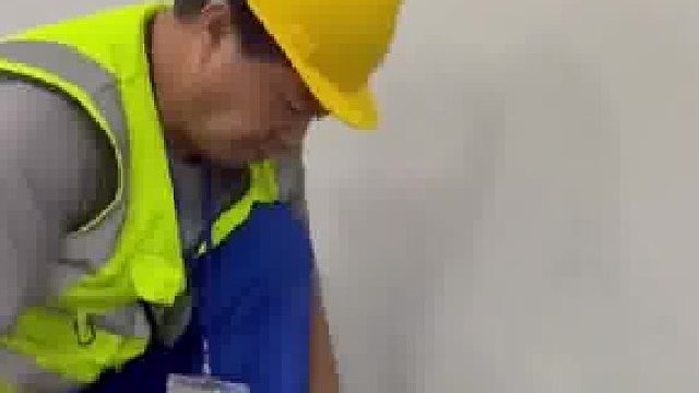 工人用橡胶锤敲击拼接板，将连接处敲得严丝合缝毫无痕迹