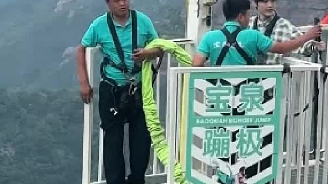 小伙子夏天蹦极故意迈脚假装跳下，吓得工作人员立马把他拉回来，网友：大哥怕自己被带下去了