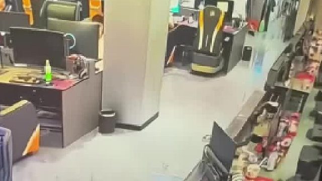 小伙把腿放在网吧桌子上，没想到一用力把桌子推倒了