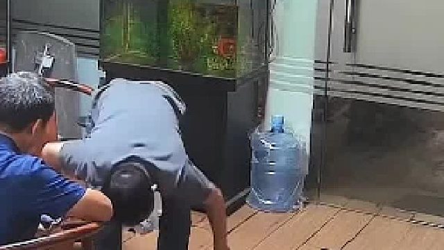 二人正在研究零件玻璃却突然裂开，男子上前拉动把手玻璃瞬间全碎在地上。