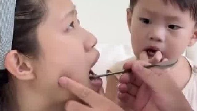 爸爸装作给妈妈检查牙齿，反手把药喂进宝宝嘴里