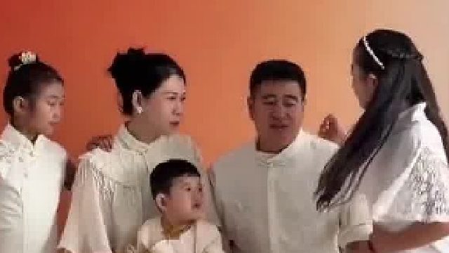 一家五口拍全家福两个女儿选站位，大女儿被推到身后小女儿被抱怀