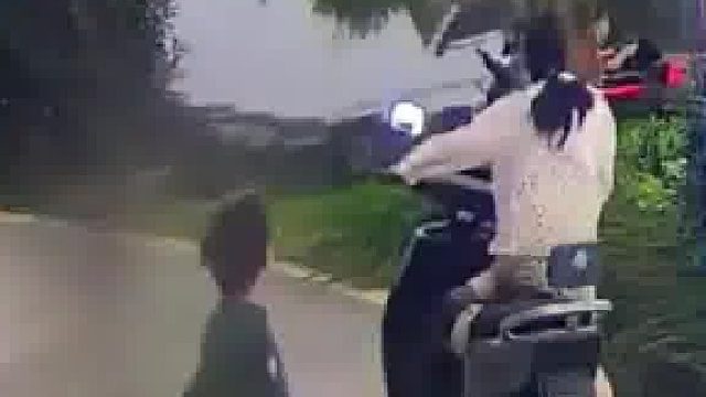 家长刚把小孩带出来玩具车就带着小孩滑进了水里，父母看见吓得赶紧跑去捞