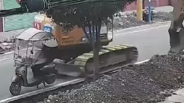 挖机往后倒车时不小心撞倒电瓶车，吓得司机立马就抬起挖机的“一条腿”，网友：求挖机师傅的心理阴影面积_