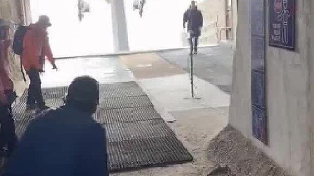 国外游客坐缆车时，需要工作人员发力将游客推上去