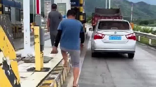 男子开车不小心把收费站墙角撞坏,尽管工作人员不追究,但自己心里过意不去,于是就弄来材料动手给修补了