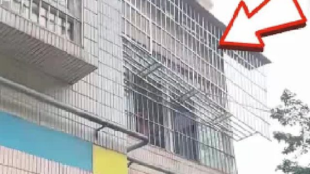 楼上邻居安装的防盗网悬挂在半空 大妈不乐意 觉得挡住自己晒太阳了