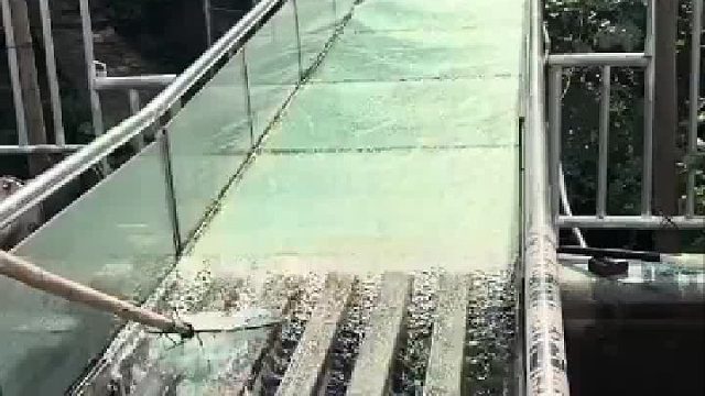 小伙玩玻璃水滑结果人比手机先下来，工作人员拿捞网打捞手机好熟练