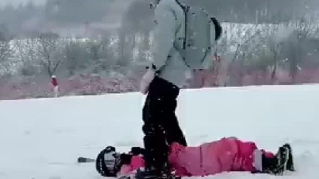 滑雪女生摔倒后静待帮助，双板从头顶一闪而过，惊险程度拉满