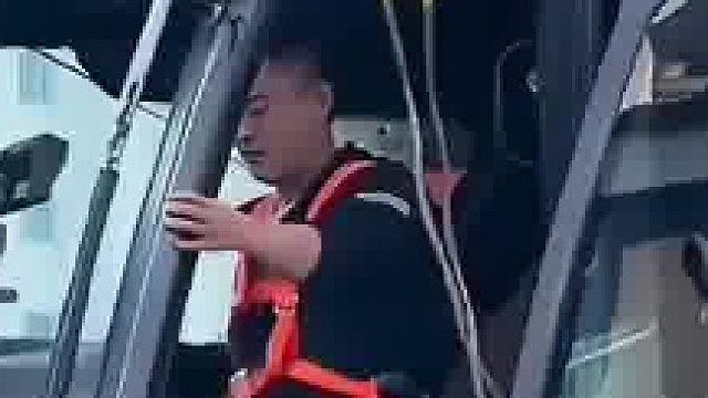 吊车作业途中吊臂弯曲，驾驶员坐在车内控制不住抖腿