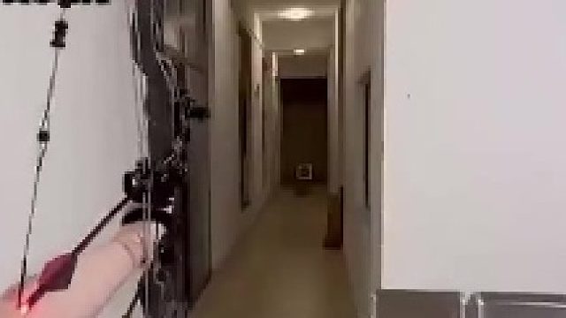 女生在家用复合弓射箭，结果左手被弓弦给打到了