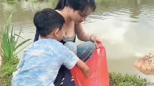 女子晒出带着孩子一起来小河边放生，满满的一袋小鱼，让它们回归大自然的怀抱