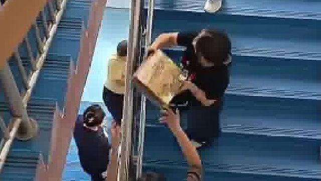 老师们发现搬书上楼的新方法，大家站着不动就能把书送上楼