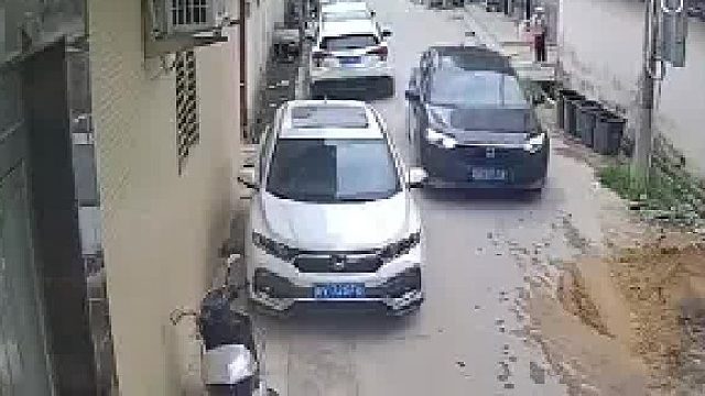 黑色车辆通过狭窄道路时，估算失误与白车擦着过撞掉后视镜