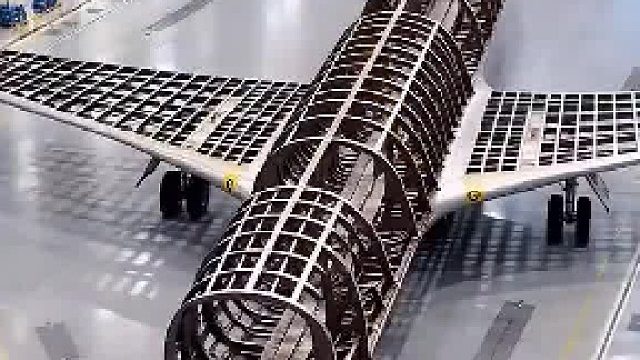工厂里正在建造一架奇特飞机，机身顶部加装了两对巨大机翼