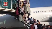 阿富汗机场画面：男子挤上飞机不见妇女儿童，美军架枪匍匐机坪
