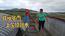 他家老婆爬上房顶排水，昨夜暴雨，屋顶积水了