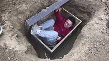 小伙模仿电影中被困棺材里的场景，在里面喝口水都不容易，太难了