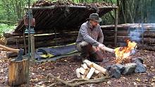 自然倾斜的庇护所-在树林里的丛林小屋里觅食栗子，打火石和钢火照明和篝火煮熟的烤牛肉。