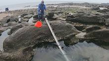 退潮后水坑里搁浅的东西太诱人，阿阳用卷水车抽干，直接捡鱼