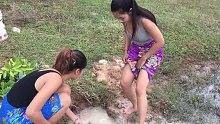 柬埔寨两个小姐姐在池塘边做陷阱捕鱼，好欢乐