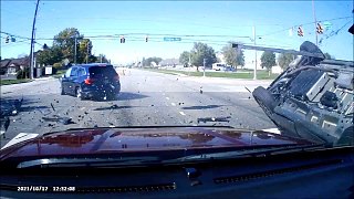 美国一汽车闯红灯被撞飞 结果掉到另一辆车顶部