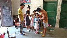 要开学了，小明和小丫给老表女儿送新书包和裙子，看着她俩真开心