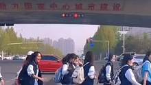网友等红绿灯的时候遇一群学生过马路 学生们纷纷向司机挥手致意
