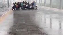 下大雨动车站内乘客被淋湿，网友：真没有一个敢打雨伞啊