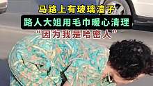 马路上有玻璃渣子，路人大姐用毛巾暖心清理，“因为我是哈密人”，来源：@哈密市融媒体中心